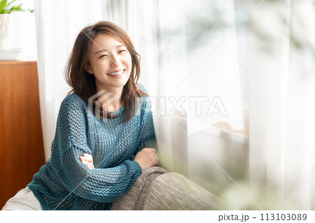部屋でリラックスする若い女性 113103089