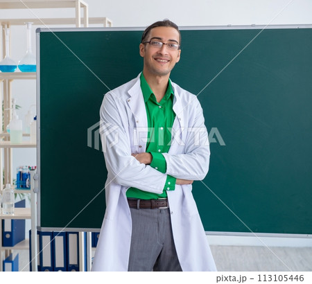 Young male chemist teacher in front of blackboard Young male chemist teacher in front of blackboard 113105446
