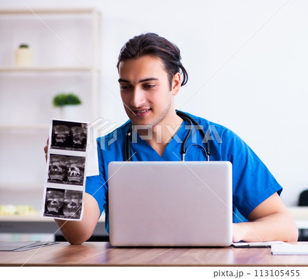 Young male doctor looking at doppler images Young male doctor looking at doppler images 113105455