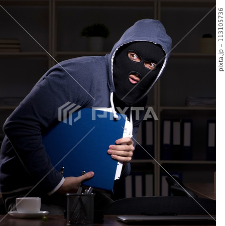 Male thief in balaclava in the office night time Male thief in balaclava in the office night time 113105736