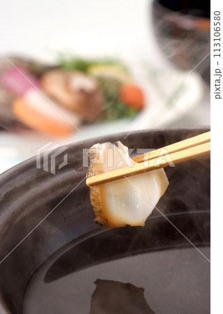 箸で持ち上げたアワビの切り身・アワビしゃぶしゃぶのイメージ・湯気がたつアワビのしゃぶしゃぶイメージ 113106580