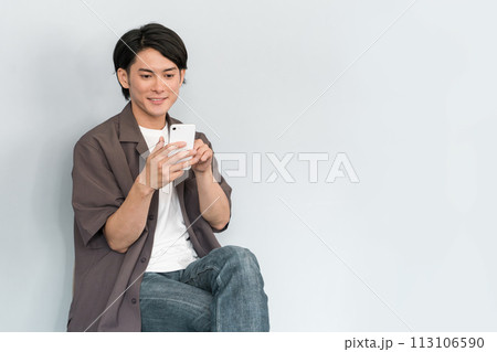 スマホを使う若いアジア人男性（検索・調べる） 113106590