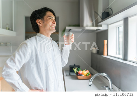 キッチンで水・白湯を飲む若いアジア人男性(水分補給・温活) キッチンで水・白湯を飲む若いアジア人男性(水分補給・温活) 113106712