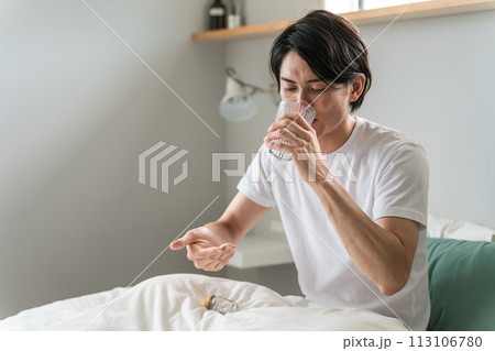 寝室で内服薬・サプリ・医薬品を飲む病気の男性・投薬 113106780