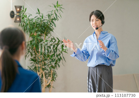 マイクを使って説明をする女性 113107730
