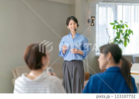 マイクを使って説明をする女性 113107732