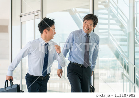 ビジネス街・オフィス街を笑顔で歩く男性ビジネスマン（通勤・出社・営業・訪問販売） 113107902