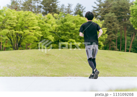 公園でウォーキング・ジョギング・ランニング・運動・有酸素運動・トレーニングをする若い男性 113109208