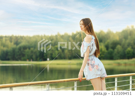 Young woman enjoying serene lake view 113109451