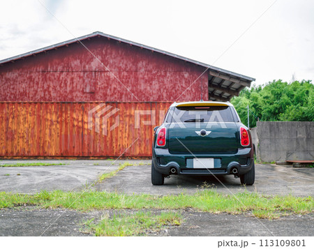 トタンが錆びた建物のそばに停車するSUV 113109801