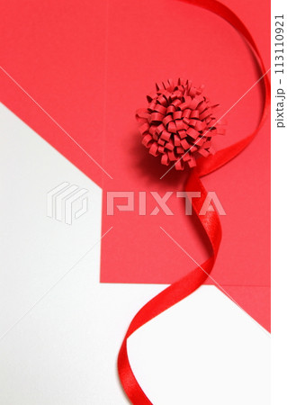 【背景素材】赤いリボンと紙の花・プレゼントイメージ（人物なし・コピースペース） 113110921