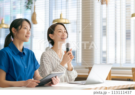 マイクを持って質問をする女性 113111437