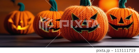 A lineup of four knitted pumpkins with smiles creates a playful Halloween scene 113111719