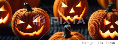 A knitted pumpkins with glowing smiles creates a playful Halloween scene 113111730