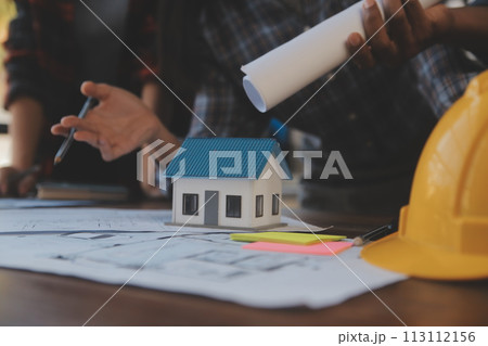 A team of construction engineers talks to managers and construction workers at the construction site. Quality inspection, work plan, home and industrial building design project 113112156