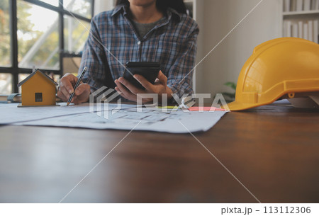 A team of construction engineers talks to managers and construction workers at the construction site. Quality inspection, work plan, home and industrial building design project A team of construction engineers talks to managers and construction workers at the construction site. Quality inspection, work plan, home and industrial building design project 113112306