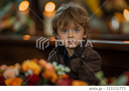 A sad little Caucasian boy at a funeral ceremony in a church A sad little Caucasian boy at a funeral ceremony in a church 113112775