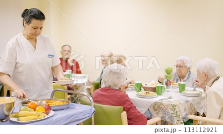 Cook serving food to seniors in a geriatric Cook serving food to seniors in a geriatric 113112921