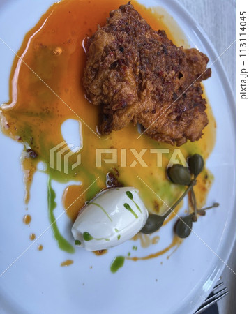 Buttermilk fried chicken and capers on white plate with honey butter at Valetta restaurant, Malta 113114045