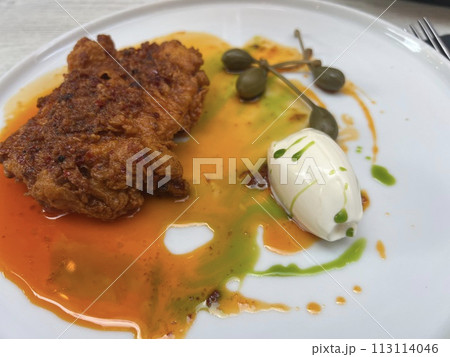 Buttermilk fried chicken and capers on white plate with honey butter at Valetta restaurant, Malta 113114046