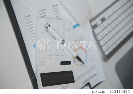 Laptop and paperwork on conference table 113114826