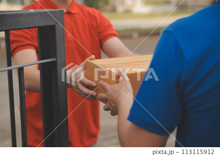 Asian delivery express courier young man use giving boxes to woman customer he wearing protective face mask at front home 113115912