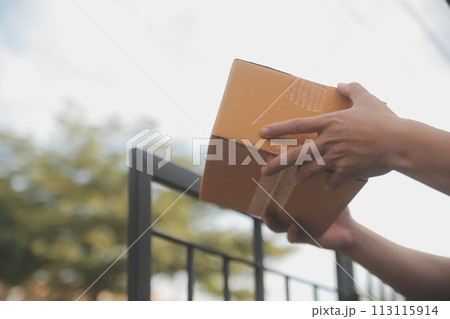 Asian delivery express courier young man use giving boxes to woman customer he wearing protective face mask at front home 113115914