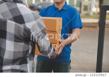 Asian delivery express courier young man use giving boxes to woman customer he wearing protective face mask at front home 113115917