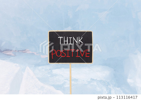 Think positive symbol. Concept words Think positive on beautiful yellow black blackboard. Beautiful blue ice background. Business, motivational think positive thinking concept. Copy space. 113116417