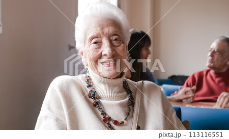 Portrait of smiling senior woman sitting in nursing home 113116551