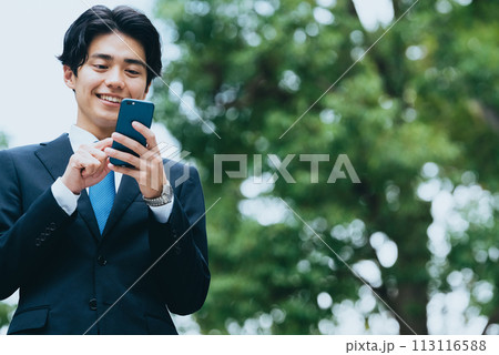 屋外でスマホを見るビジネスマン 113116588