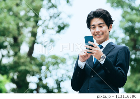 屋外でスマホを見るビジネスマン 113116590