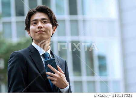 オフィス街でスマホを持つビジネスマン オフィス街でスマホを持つビジネスマン 113117028