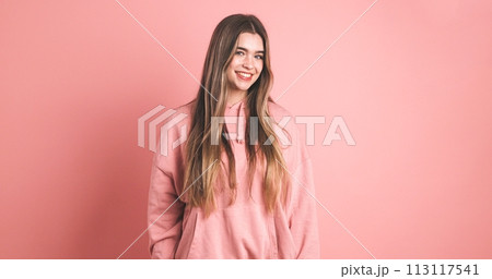 Happy woman with long hair smiling in pink studio Happy woman with long hair smiling in pink studio 113117541
