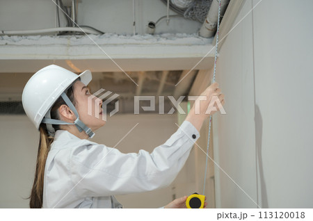 巻き尺で長さを計測するエンジニアの女性 113120018