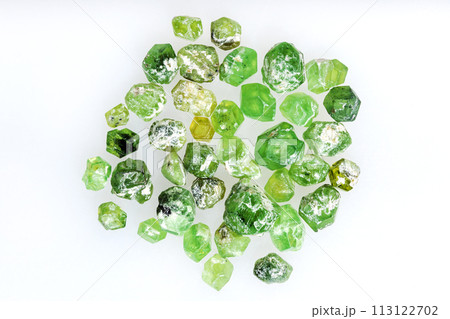 many unpolished demantoid crystals on white 113122702
