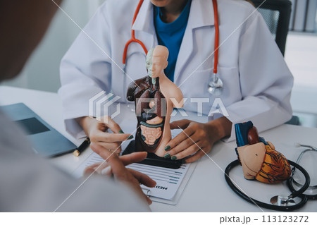 Doctor explaining heart to elderly patient. Doctor explaining the heart model. Doctors pen point to a model of the heart Doctor explaining heart to elderly patient. Doctor explaining the heart model. Doctors pen point to a model of the heart 113123272