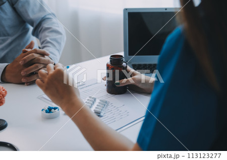 Doctor explaining brain functions to patient on model in office. 113123277