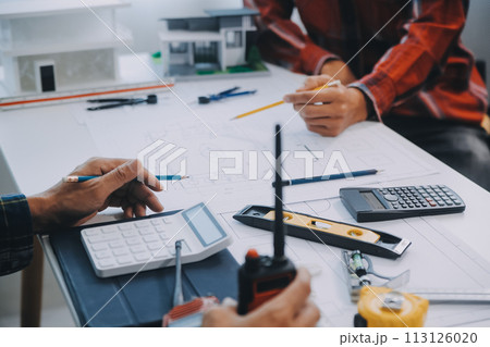 engineer people meeting working and pointing at a drawings in office for discussing. Engineering tools and construction concept. engineer people meeting working and pointing at a drawings in office for discussing. Engineering tools and construction concept. 113126020