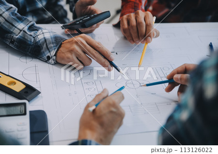 engineer people meeting working and pointing at a drawings in office for discussing. Engineering tools and construction concept. 113126022