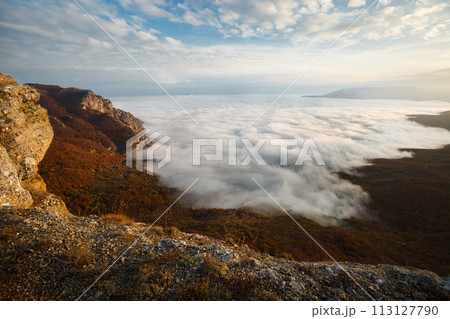 Dramatic sunset landscape in yellow autumn high mountains over clouds. Beautiful scenery of sky 113127790