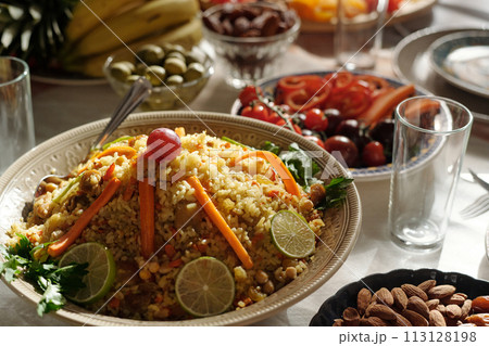 Selective focus closeup of pilaf decorated with slices of lime, carrot and grape on festive table prepared for Eid Al-Fitr celebration Selective focus closeup of pilaf decorated with slices of lime, carrot and grape on festive table prepared for Eid Al-Fitr celebration 113128198