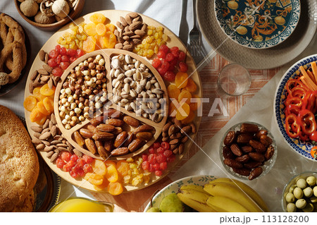 No people flat lay shot of sweet dried fruit and nits on platter on festive table served for Islamic holiday celebration No people flat lay shot of sweet dried fruit and nits on platter on festive table served for Islamic holiday celebration 113128200