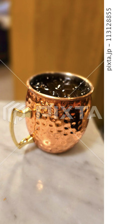 Traditional iced tea served in a unique and artistic brass cup , ice tea garnished with rosemary twigs Traditional iced tea served in a unique and artistic brass cup , ice tea garnished with rosemary twigs 113128855