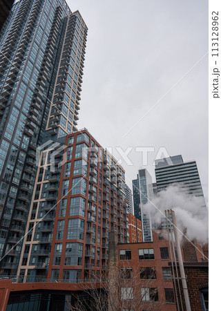 chimney pipe with steam at New York or Toronto, smoke stack on big city with skyscrapers urban background chimney pipe with steam at New York or Toronto, smoke stack on big city with skyscrapers urban background 113128962