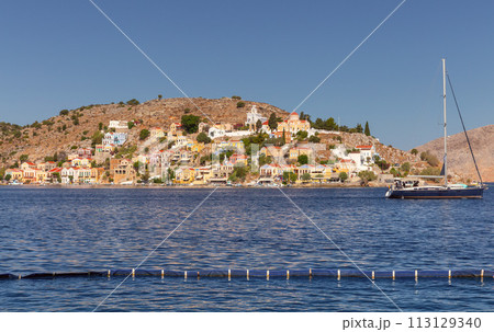 Multi-colored facades of houses in the Greek village Symi on a sunny day 113129340