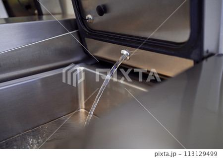 Industrial dishwasher in restaurant kitchen washing dishes 113129499