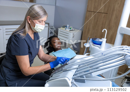 Woman dentist with patient in clinic 113129502