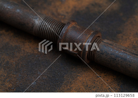 Rusty plumb tube on rusty metal wall 113129658