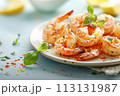 Grilled shrimp on a white plate with fresh basil and lemon on blue background 113131987
